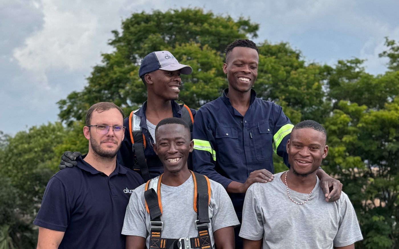 The Alumo installation team on site with solar panels